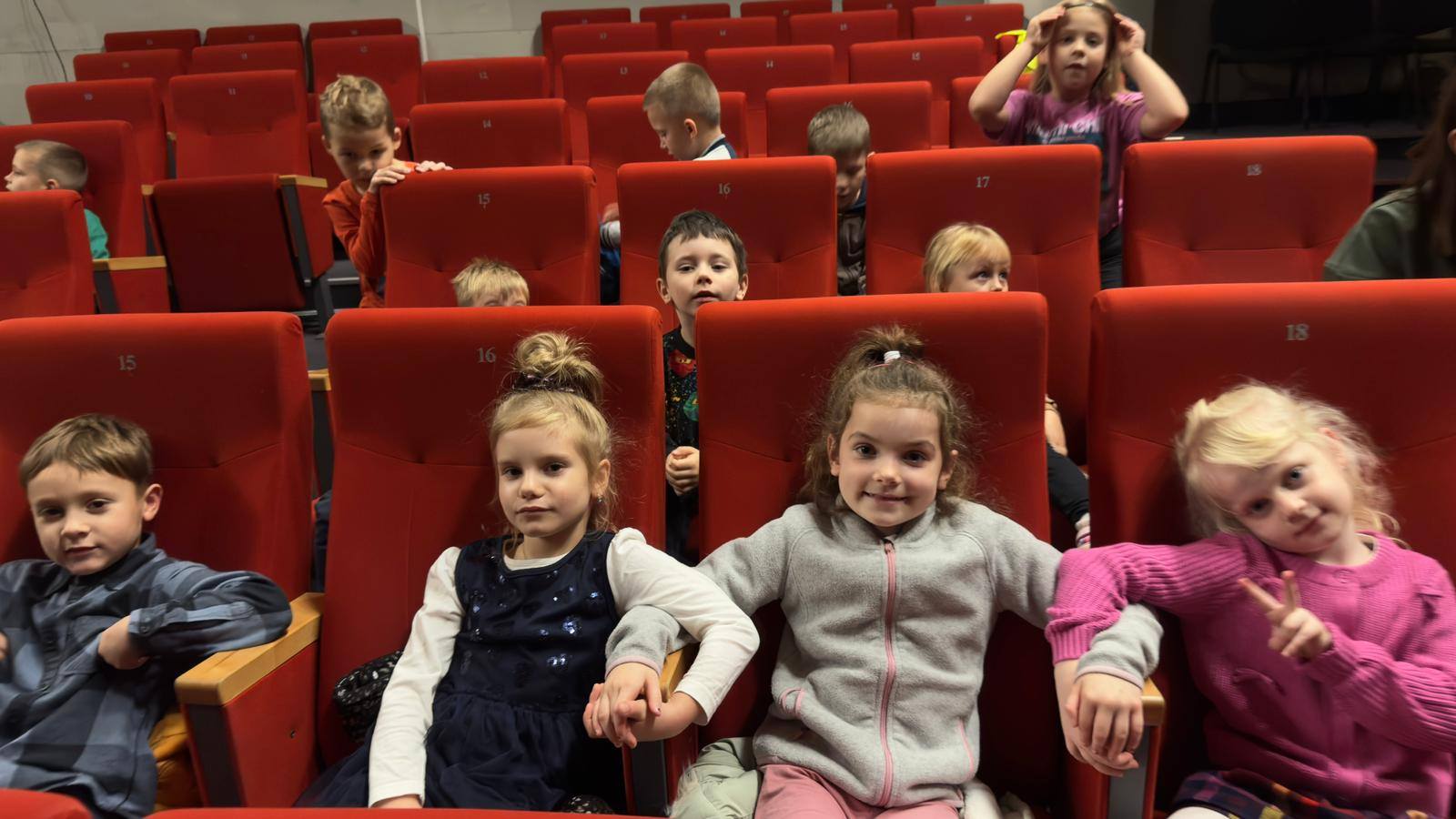  Dzieci siedzą na krzesłac...