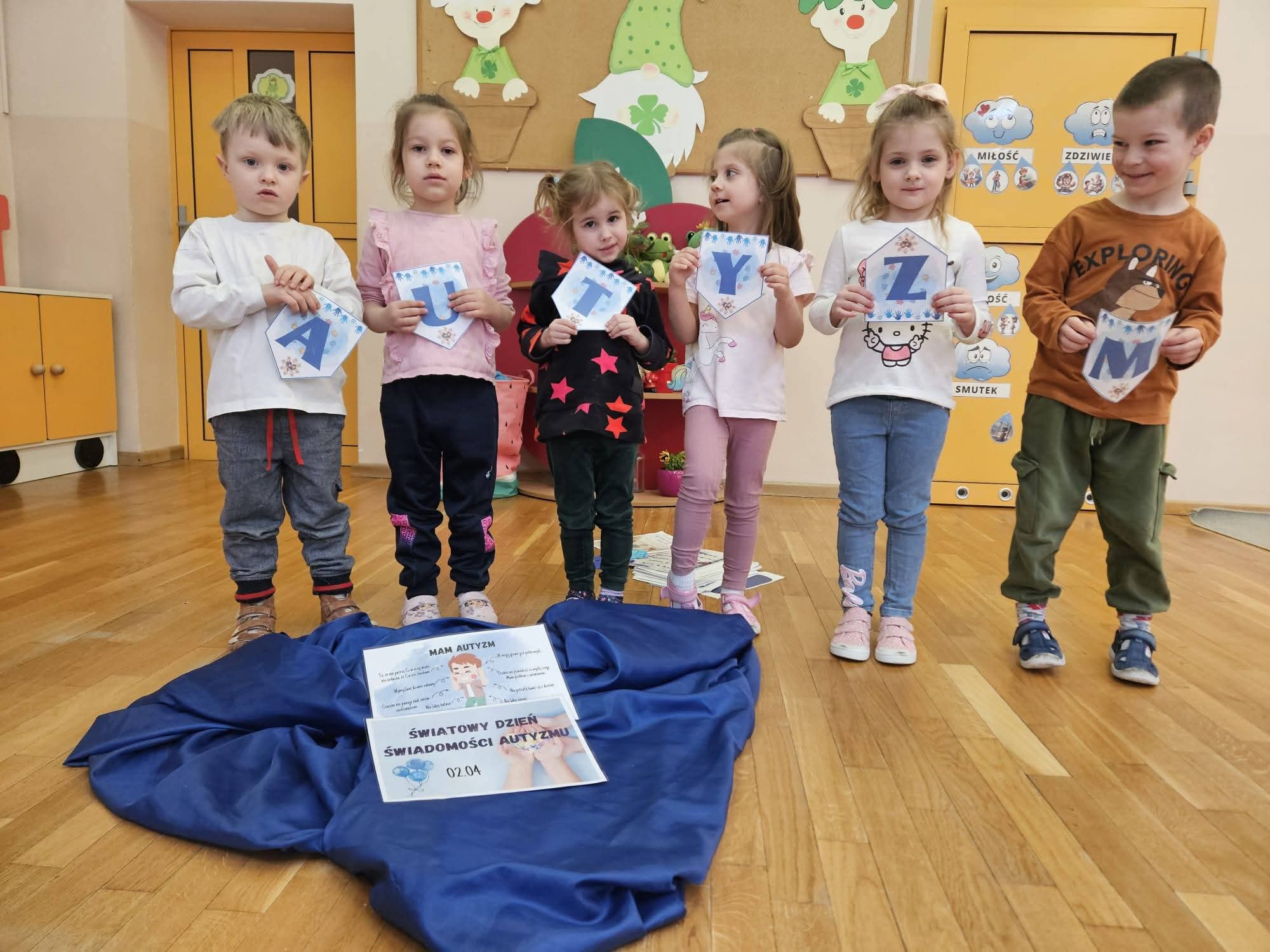  Dzieci w szeregu z kartka...