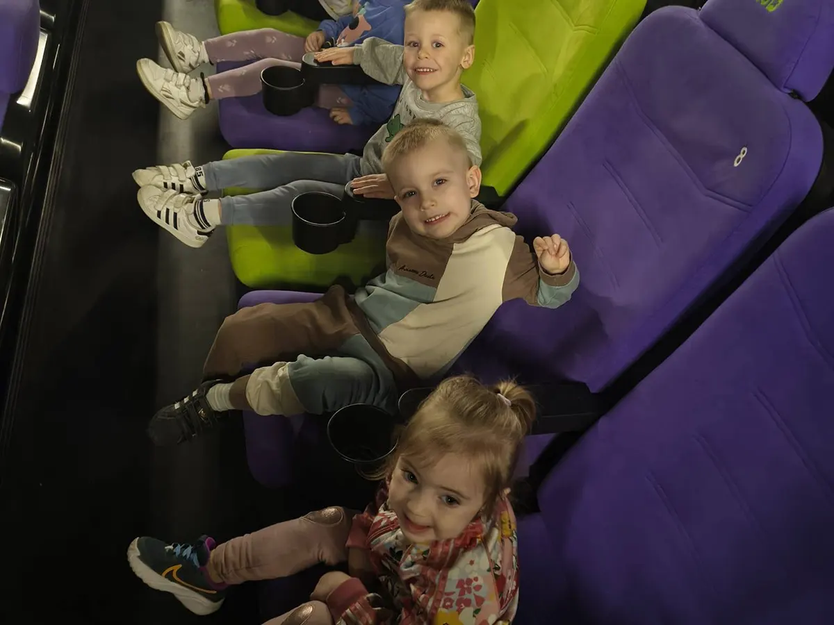  Dzieci siedzą na krzesłac...